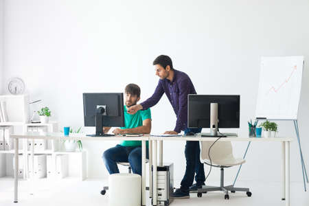 Business people discussing ideas at meeting using computer in the office
