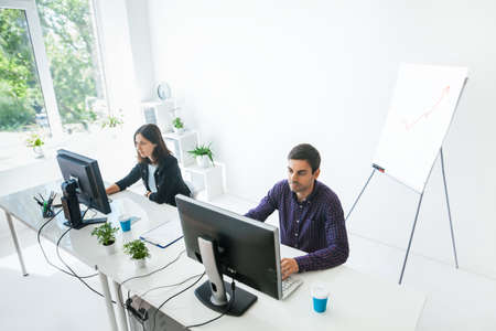 Two business people working on computer in the office. Top viewの写真素材