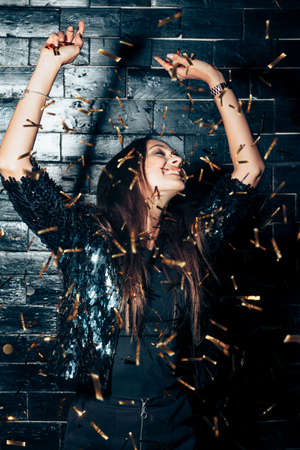 Young beautiful woman dancing in confetti and enjoying party. Happiness. New year, Birthday, Holiday Event conceptの写真素材