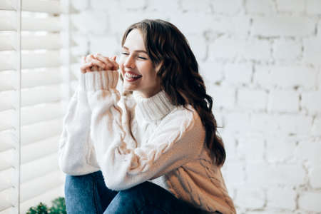 Happy laughing woman relaxing on window sill. Freedom conceptの写真素材