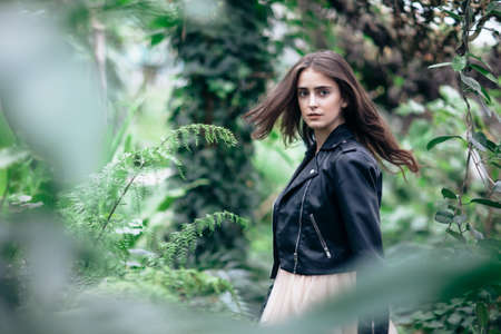 Fashion portrait of beautiful stylish girl in motion posing on nature background. Beauty concept