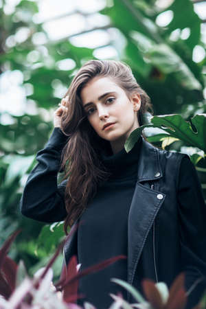 Fashion portrait of beautiful stylish woman in leather jacket on nature backgroundの写真素材