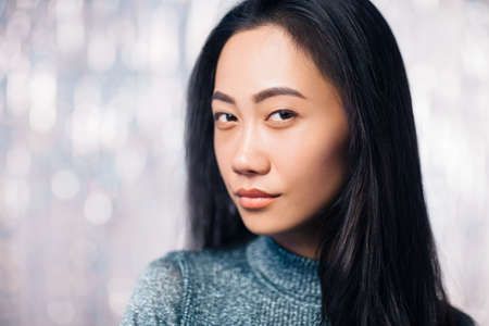 Portrait of a cute eastern girl closeup. Young brunette with curly long hair elegantly posing,...