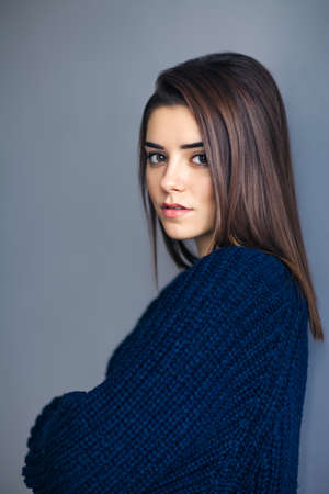 Young beautiful brunette woman portrait on gray backgound