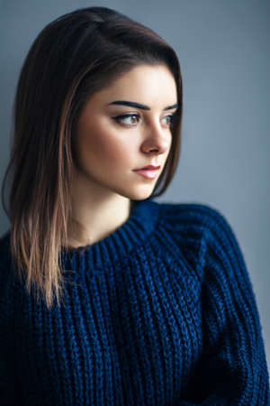 Close up profile portrait of young beautiful woman against gray backgroundの写真素材