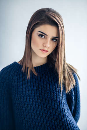 Close up portrait of beautiful brunette young woman on gray studio backgound