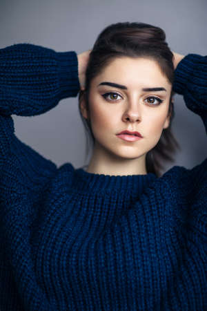 Close up portrait of beautiful brunette young woman on gray studio backgoundの写真素材