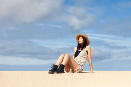 Beautiful young woman relaxing on sand. Fashion portrait. Vacation conceptの写真素材