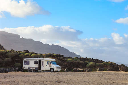 Caravan trailer parked on a beach with mountains view on Canary island. Summer vacation. Travel concept.の写真素材