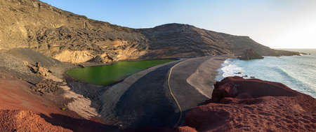 Large panorama of a black beach, volcanic crater with green lake (El Lago Verde, Charco de los Clicos)  in El Golfo. Lanzarote. Canary Islands. Spainの写真素材