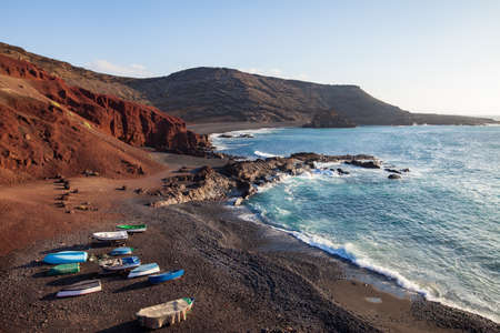 Unique black sand beach and fishing boats at El Golfo, Lanzarote, Canary Islands. Travel conceptの写真素材