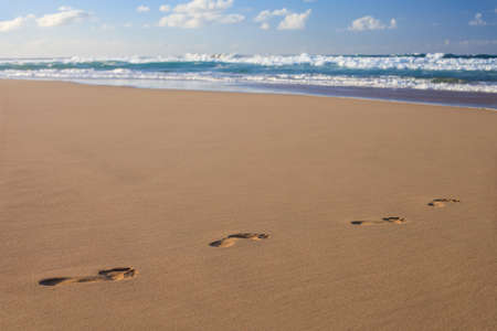 Footprints in the sand on ocean beach. Footsteps on the shore. Summer vacation concept. Copy spaceの写真素材