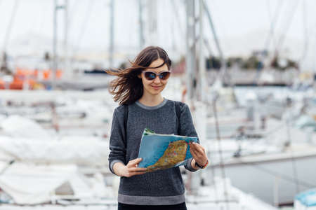 Young attractive female traveler sightseeing new city with map. Travel concept.の写真素材