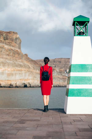Traveler woman near lighthouse enjoy mountain and ocean. Travel concept.の写真素材