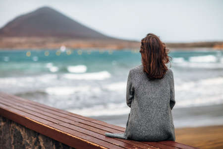 Back view of young woman enjoy the ocean. Relax concept. Fuerteventura, Canary islands, Spain.の写真素材