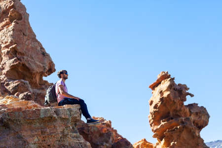 Traveler man sitting on mountain in canyon. National park of Tenerife, Canary Islands, Spainの写真素材