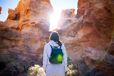 Traveler woman enjoy picturesque mountains in canyon backlit by sun. Travel conceptの写真素材