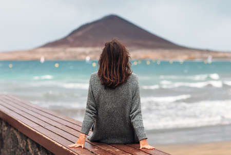 Back view of young woman enjoy the ocean. Relax concept. Fuerteventura, Canary islands, Spain.の写真素材