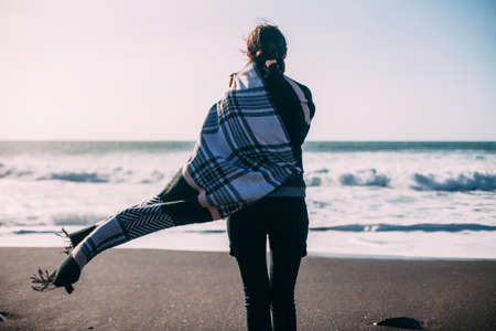 Back view of young lonely woman enjoying ocean. Depressionの写真素材