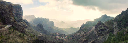 Panoramic view of fantastic mountains range in fog on sunset,  Gran Canaria, Canary Islands, Spain. Nature backgroundの写真素材
