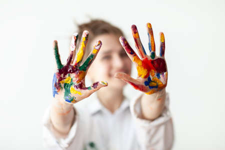 Happy woman showing hands painted in colorful paints on white background. Fun conceptの写真素材