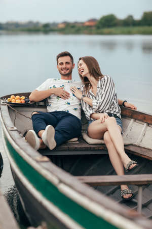Happy couple having fun relaxing in boat on lake. Romantic date. Relationship conceptの写真素材