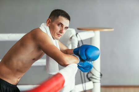 Portrait of muscular handsome boxer relax on boxing ring backgroundの写真素材