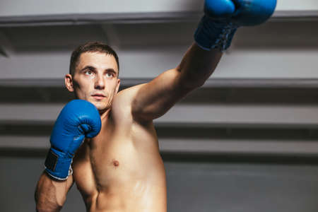 Male boxer during boxing exercise making direct hit. Sport concept  jab