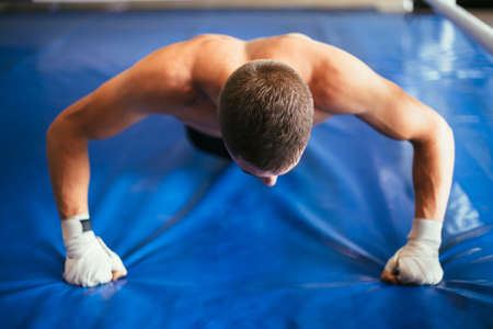 Athlete man doing pushup exercise in gymの写真素材