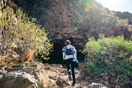 Hiker woman climbing to mountain cave in Gran Canaria island