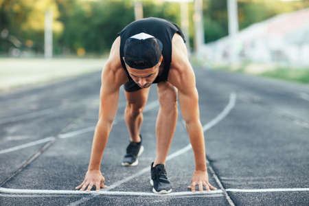 Runner man on the start. Sprinter on the start line of the track in stadiumの写真素材