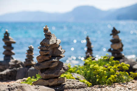 Balance of stones. Stones pyramids on pebble beach in Sardinia Island, Italy. Concept of harmonyの写真素材