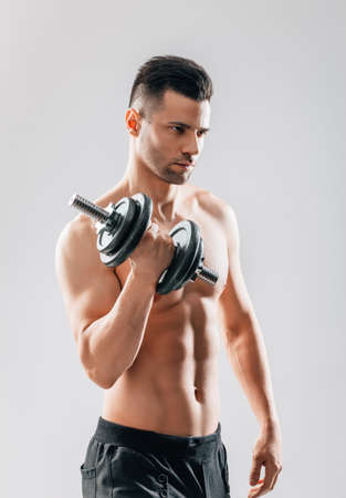 Muscular bodybuilder man doing exercises with dumbbell. Sport conceptの写真素材