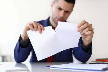 Disappointment business man tearing a sheet of white paper. Business failure conceptの写真素材