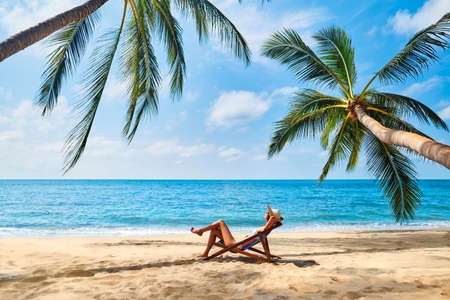 Young beautiful woman sunbathe and relax on tropical beachの写真素材
