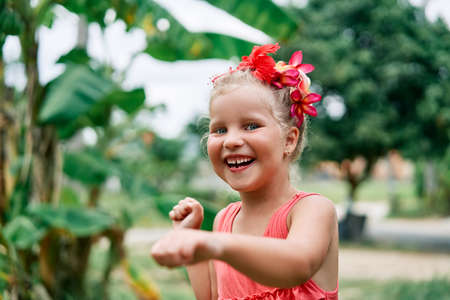Happy smiling little girl portrait dancing on summer day in the streetの写真素材