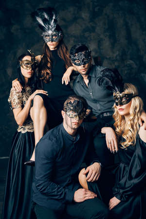 Group of people in masquerade carnival mask posing in studioの写真素材