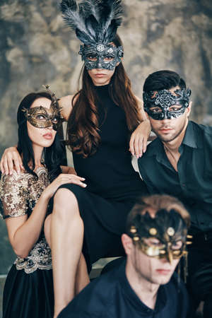 Group of people in masquerade carnival mask posing in studio