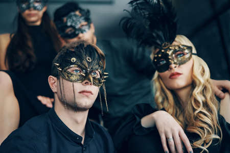 Group of people in masquerade carnival mask posing in studioの写真素材
