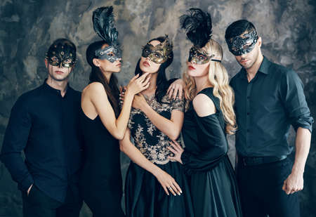 Group of people in masquerade carnival mask posing in studioの写真素材