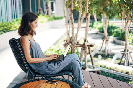 Young beautiful woman working on laptop outdoorsの写真素材