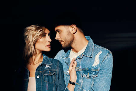Closeup portrait of young and beautiful couple wearing denim jeansの写真素材