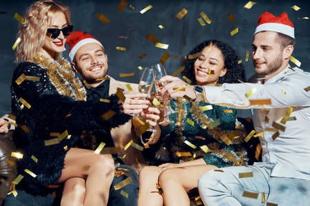 Multiethnic friends toasting with champagne celebrating Christmas partyの写真素材