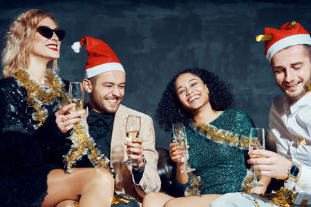 Group of happy smiling friends celebrate New Year together, having fun and drinking champagneの写真素材