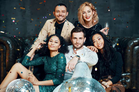 Diverse group of happy young friends having fun enjoying party and drinking champagne