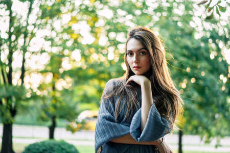 Young beautiful woman outdoors on green background summer nature.  Close up portrait