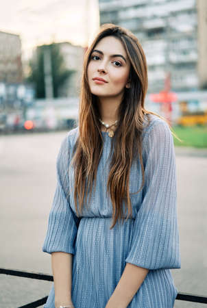 Close up young beautiful woman portrait posing in the city street in summer