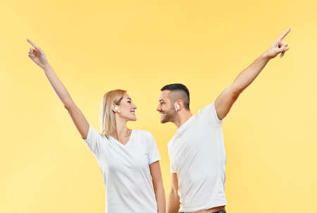 Happy couple dancing or celebrating success with hands up gesture on yellow background. victory, triumph and emotions conceptの写真素材