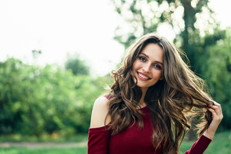 Portrait of young beautiful woman outdoors on green summer nature background. Female beauty conceptの写真素材