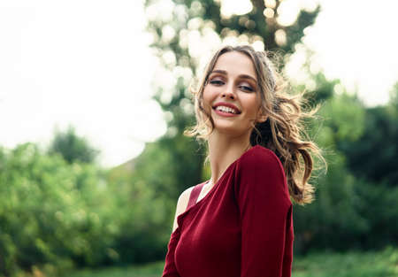 Portrait of young beautiful woman outdoors on green summer nature background. Female beauty concept
